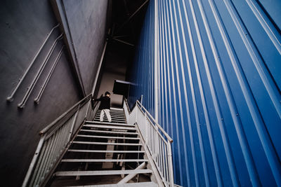 Low angle view of boy standing on staircase in building