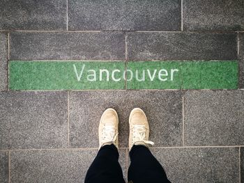 Low section of man standing on tiled floor