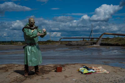 Man standing at beach against sky