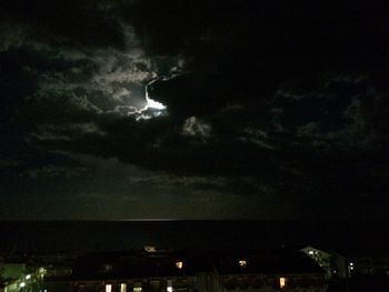 Low angle view of illuminated building against cloudy sky