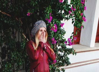 Woman standing by pink flowering plants