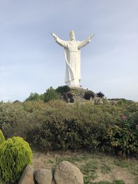 Statue of cross against sky