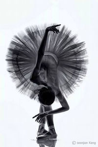 Rear view of woman dancing against white background