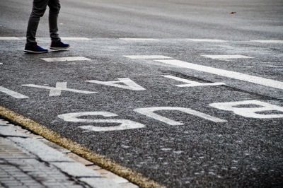 Low section of person with text on road