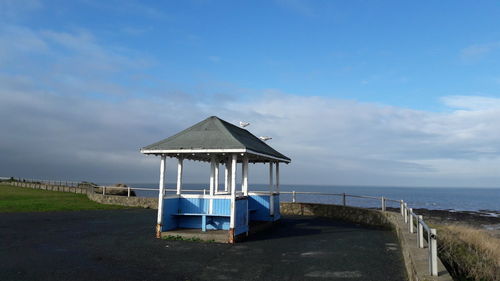 Lifeguard hut on beach against sky