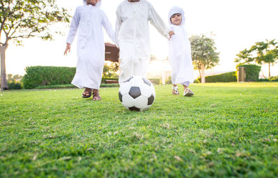 Boys playing with soccer ball on grass