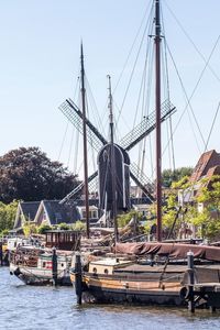 Boats moored at harbor against clear sky