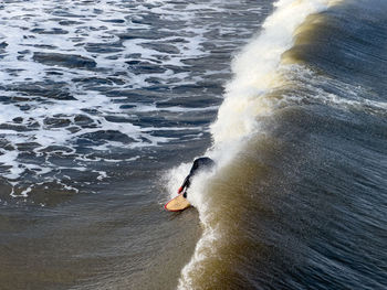 Rear view of man surfing in sea