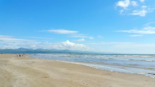 Scenic view of beach against blue sky