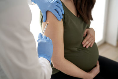 Midsection of female doctor examining patient in hospital