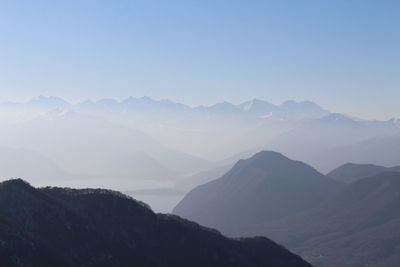 Scenic view of mountains in foggy weather during sunrise