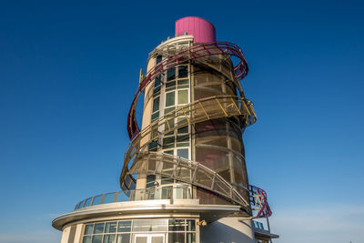 Low angle view of factory against clear blue sky