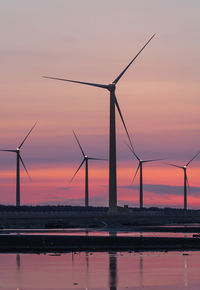 Wind turbine against sky during sunset