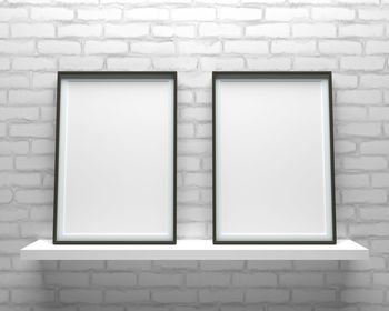 Blank picture frames against brick wall