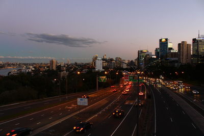 High angle view of light trails on road amidst buildings in city