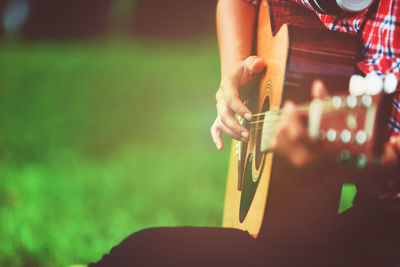 Midsection of man playing guitar