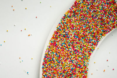 Colourful sugar sprinkles. top view, flat lay on white background.