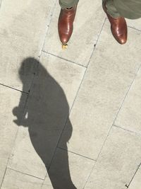 Low section of man standing on sidewalk