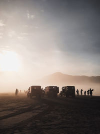 Vehicles and people standing in desert