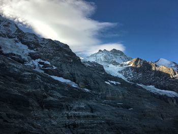 Low angle view of snowcapped mountains against sky