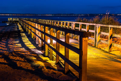 Pier over sea against clear sky during sunset