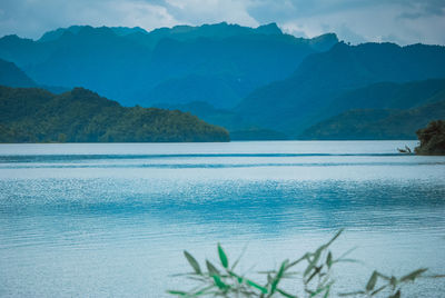 Scenic view of lake and mountains against blue sky