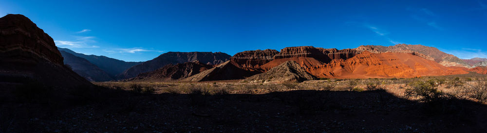 Scenic view of mountains against blue sky