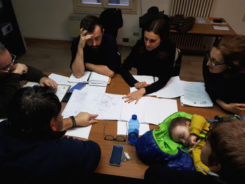 High angle view of people sitting on table