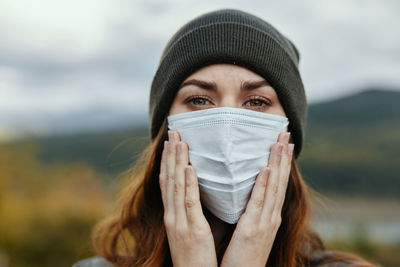 Portrait of woman in knit hat wearing protective face mask