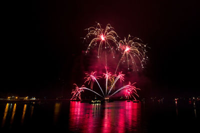 Firework display over river at night