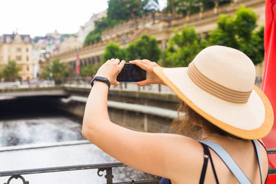 Rear view of woman holding hat