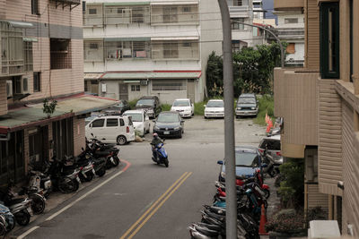 Vehicles on road by buildings in city