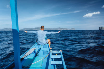 Rear view of man on sea against sky