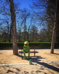 Rear view of man sitting on bench in park