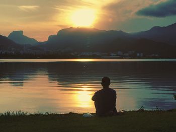 Silhouette of people at lakeshore during sunset