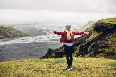 Rear view of woman standing on hill