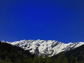 Scenic view of snowcapped mountains against clear blue sky