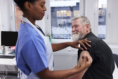 Female doctor vaccinating senior patient