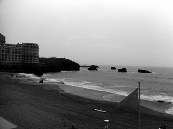 View of beach in city against sky