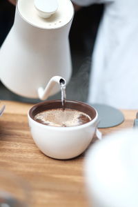 Pouring hot water in a cup