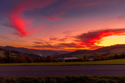 Scenic view of field against romantic sky at sunset