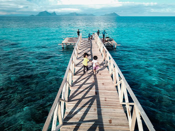 High angle view of people on pier at sea against sky