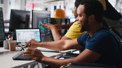 Side view of man using laptop at office