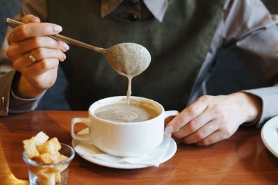 Man holding coffee cup on table