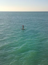 Man surfing in sea against clear sky
