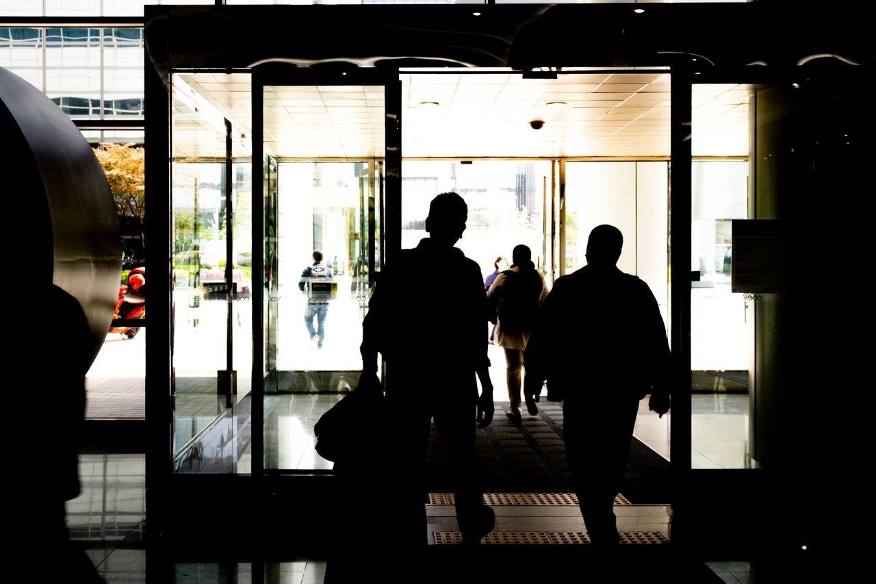 REAR VIEW OF SILHOUETTE PEOPLE WALKING ON RAILROAD STATION