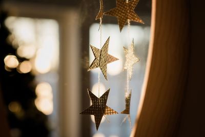 Glittery paper stars decoration sparkling in the sunlight indoors