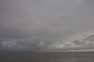 Scenic view of sea against storm clouds