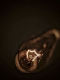 Close-up of illuminated candle against black background