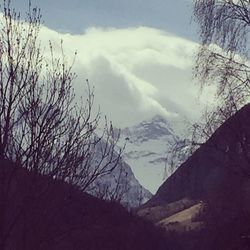 Scenic view of mountains against cloudy sky